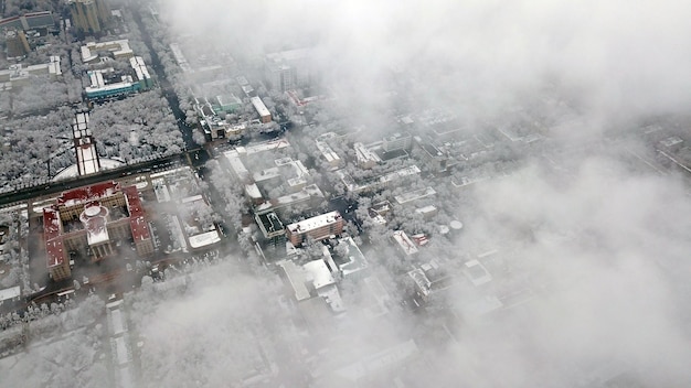 Widok z góry przez chmury na miasto almaty
