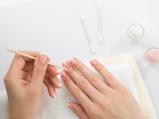 Zdjęcie widok z góry ręce kobiety za pomocą narzędzi do manicure