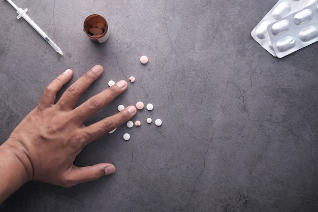 Zdjęcie widok z góry ręka człowieka z tabletek na czarno