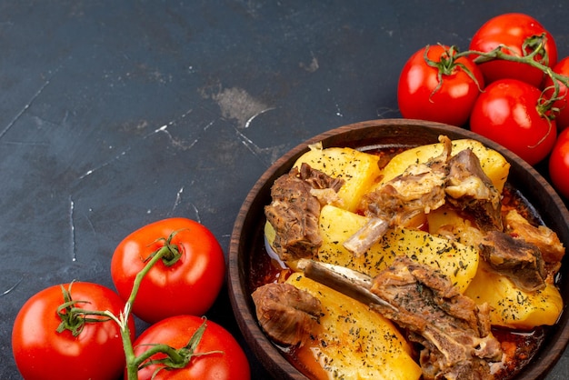Widok z góry smaczne gotowane mięso z gotowanymi ziemniakami i pomidorami na ciemnym tle danie sos gotowanie kuchnia kuchnia gorący obiad mięsny