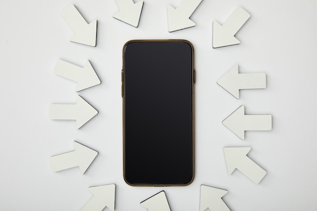 Zdjęcie widok z góry smartfona w elipsie z białymi wskaźnikami na szarym tle