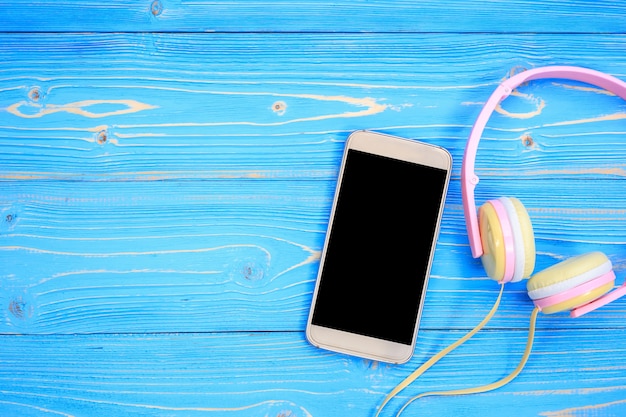 Widok z góry smartphone i nowy nowoczesny różowy słuchawek muzyki