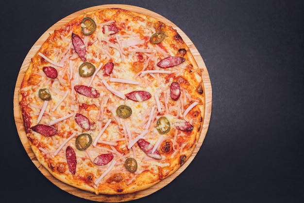 Widok z góry sycylijskiej pizzy z salami, cukinią jalapeno i papryką