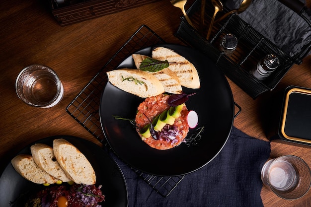 Widok z góry tatara z łososia z chlebem na stole w restauracji Wysokiej jakości zdjęcie