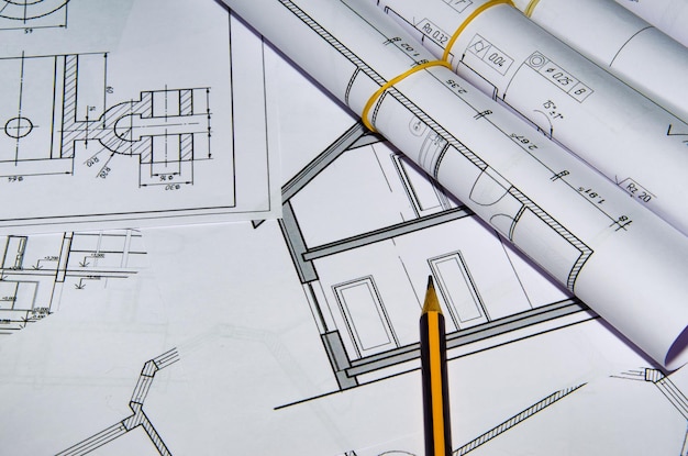 Widok z góry w miejscu pracy architekta. Projekt architektoniczny, plany, rolki z planem na stole. Tło budowlane. Narzędzia inżynierskie.