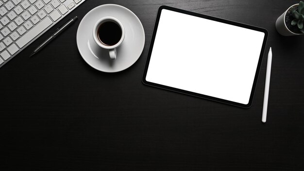 Widok z góry z cyfrowym rysikiem do tabletu i filiżanką kawy na czarnym biurku