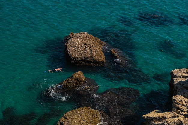 Widok Z Góry Z Lotu Ptaka Na Piękną Plażę Nerja W Hiszpanii Z Mężczyzną, Który Nurkuje