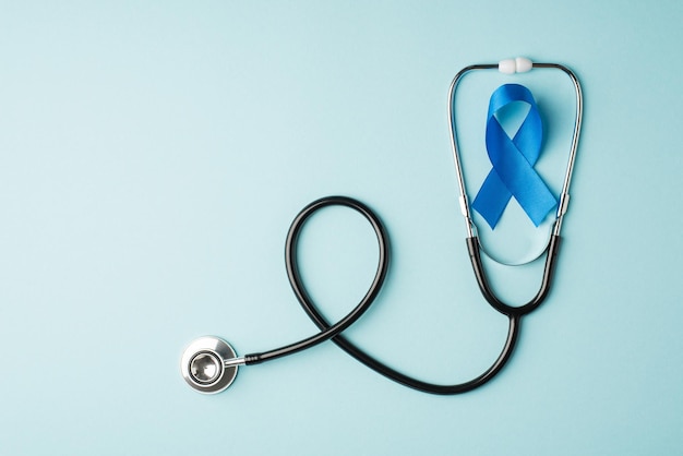 Widok z góry zdjęcia stetoskopu i symbolu niebieskiej wstążki świadomości raka prostaty na na białym tle pastelowym niebieskim tle z copyspace