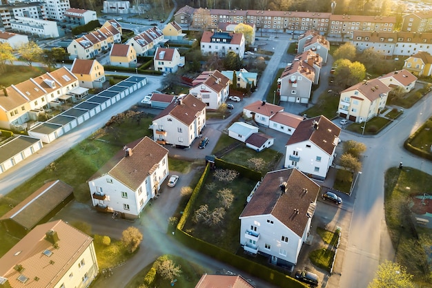 widok z lotu ptaka domów mieszkalnych z czerwonymi dachami i ulic z zaparkowanymi samochodami w wiejskiej części miasta.