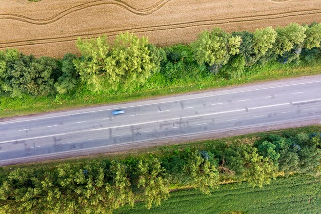 Widok Z Lotu Ptaka Drogi Między żółtymi Polami Pszenicy I Zielonymi Drzewami.