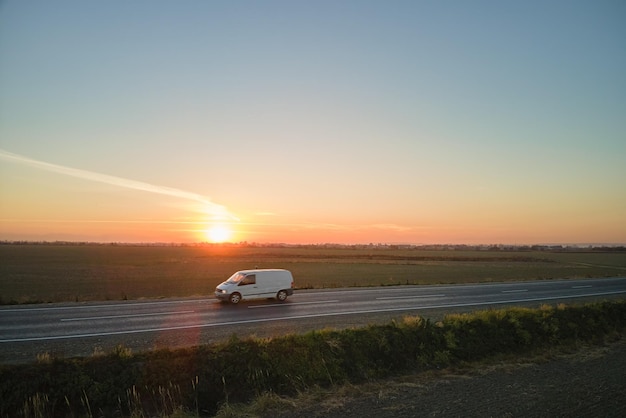 Widok z lotu ptaka drogi międzymiastowej z niewyraźnym szybkim samochodem o zachodzie słońca Widok z góry z drona ruchu autostradowego wieczorem