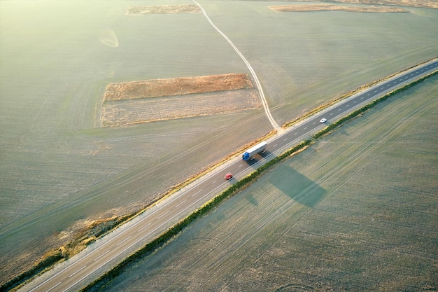 Widok z lotu ptaka drogi międzymiastowej z szybkimi samochodami o zachodzie słońca Widok z góry z drona ruchu autostradowego wieczorem