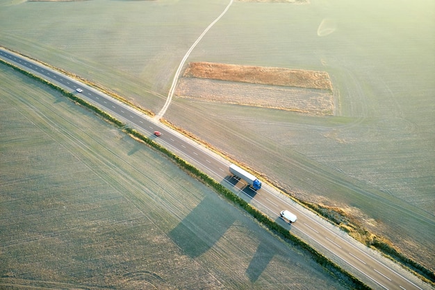 Widok z lotu ptaka drogi międzymiastowej z szybkimi samochodami o zachodzie słońca Widok z góry z drona ruchu autostradowego wieczorem