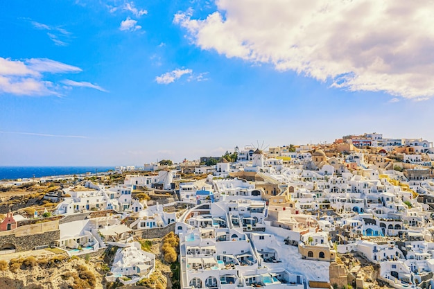 Widok z lotu ptaka drona na słynną wioskę Oia z białymi domami i niebieskimi kopułami kościołów na wyspie Santorini Morze Egejskie Grecja