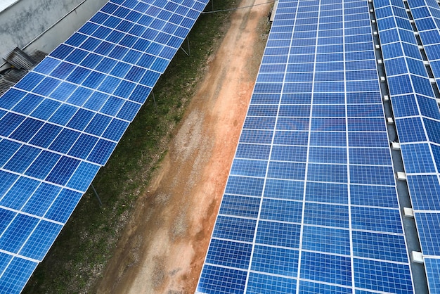 Widok z lotu ptaka elektrowni słonecznej z niebieskimi panelami fotowoltaicznymi zamontowanymi na dachu budynku przemysłowego do produkcji zielonej ekologicznej energii elektrycznej Produkcja koncepcji zrównoważonej energii