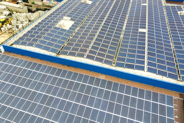 Widok Z Lotu Ptaka Elektrowni Słonecznej Z Niebieskimi Panelami Fotowoltaicznymi Zamontowanymi Na Dachu Budynku Przemysłowego.