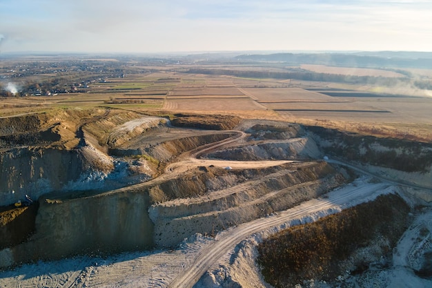 Widok z lotu ptaka kopalni odkrywkowej materiałów z piaskowca dla budownictwa z koparkami i wywrotkami. Koncepcja ciężkiego sprzętu w górnictwie i produkcji użytecznych minerałów