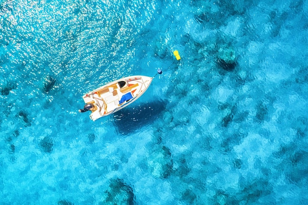 Widok z lotu ptaka łodzi w czystej, błękitnej wodzie w słoneczny dzień w lecie Widok z góry z drona jachtu piaszczysta plaża na Morzu Śródziemnym Podróż w Turcji Oludeniz Tropikalny krajobraz z motorówką