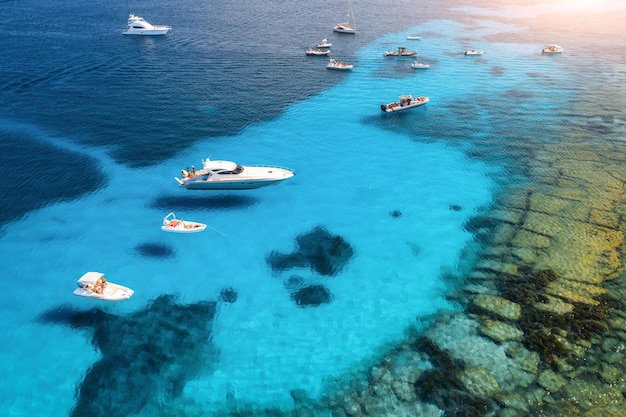 Widok z lotu ptaka luksusowych jachtów na błękitne morze o zachodzie słońca latem Sardynia Włochy Widok z góry łodzi motorowych jachtów morze Laguna brzeg przezroczysta woda Widok z góry z drona Tropikalny pejzaż morski