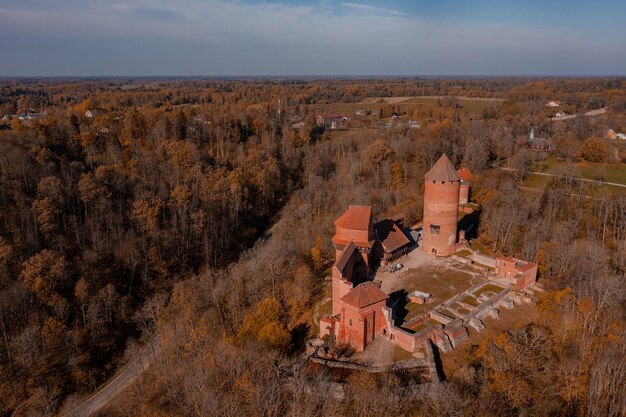 Widok z lotu ptaka miasta Sigulda na Łotwie podczas złotej jesieni. Średniowieczny zamek w środku lasu.