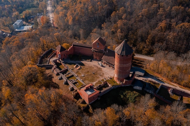 Widok z lotu ptaka miasta Sigulda na Łotwie podczas złotej jesieni. Średniowieczny zamek w środku lasu.