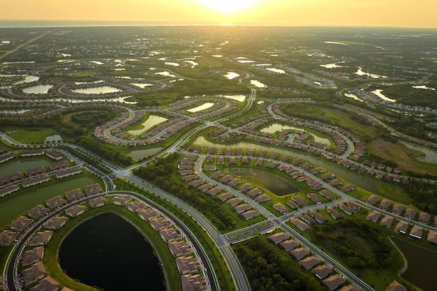 Widok z lotu ptaka na ciasno położone domy rodzinne ze stawami retencyjnymi, aby zapobiec powodziom na zamkniętym obszarze podmiejskim na Florydzie Rozwój nieruchomości na amerykańskich przedmieściach