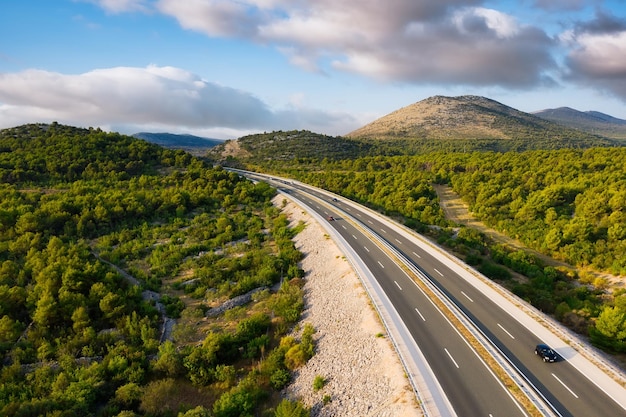 Widok z lotu ptaka na drogę Autostrada przez dolinę górską Widok z drona Naturalny krajobraz w okresie letnim z powietrza Podróże i wakacje Transport obraz
