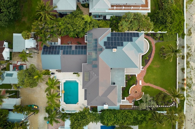 Widok z lotu ptaka na drogi amerykański dach domu z niebieskimi panelami fotowoltaicznymi do produkcji czystej ekologicznej energii elektrycznej Inwestowanie w odnawialną energię elektryczną dla dochodu emerytalnego