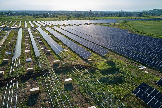 Widok z lotu ptaka na dużą elektrownię w budowie z wieloma rzędami paneli słonecznych na metalowej ramie do produkcji czystej energii elektrycznej Rozwój odnawialnych źródeł energii elektrycznej