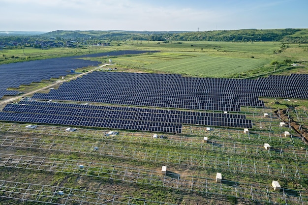 Widok z lotu ptaka na dużą elektrownię w budowie z wieloma rzędami paneli słonecznych na metalowej ramie do produkcji czystej energii elektrycznej Rozwój odnawialnych źródeł energii elektrycznej
