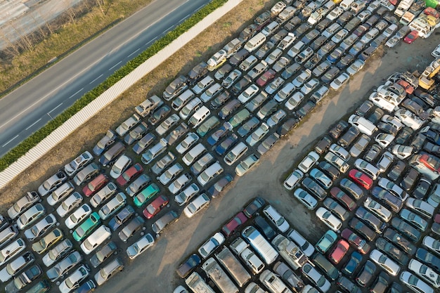 Widok z lotu ptaka na duży parking na złomowisku z rzędami wyrzuconych zepsutych samochodów Recykling starych pojazdów