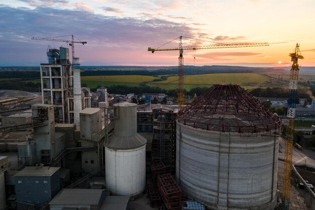 Widok z lotu ptaka na fabrykę cementu w budowie z wysoką konstrukcją betoniarską i żurawiami wieżowymi w obszarze produkcji przemysłowej Produkcja i koncepcja globalnego przemysłu