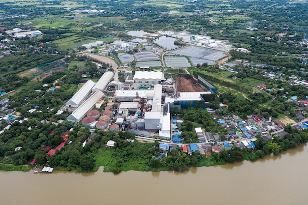 Widok z lotu ptaka na fabrykę przemysłową z magazynem, zbiornikami i maszyną w zielonej okolicy