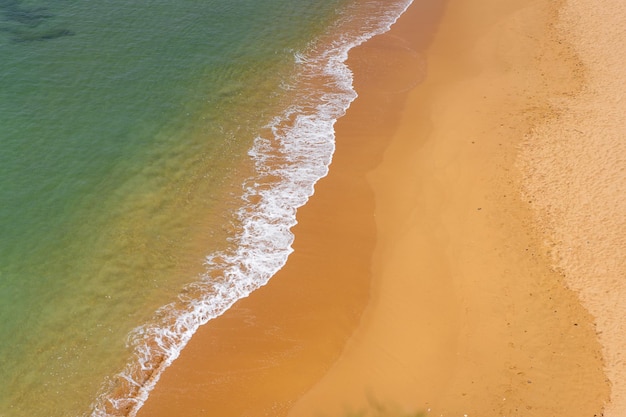 Widok z lotu ptaka na fale morskie i piaszczystą plażę