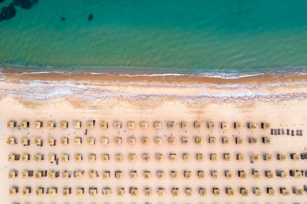 Widok z lotu ptaka na fantastyczną plażę z parasolami i spokojnym morzem