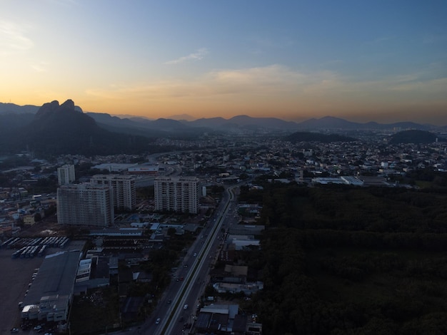 Widok z lotu ptaka na Jacarepagua w Rio de Janeiro Brazylia Budynki mieszkalne i góry w tle Słoneczny dzień Zachód słońca Zdjęcie drona