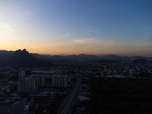 Widok z lotu ptaka na Jacarepagua w Rio de Janeiro Brazylia Budynki mieszkalne i góry w tle Słoneczny dzień Zachód słońca Zdjęcie drona