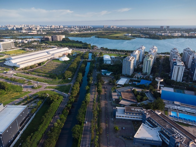 Widok Z Lotu Ptaka Na Lagunę Jacarépagua W Rio De Janeiro, Brazylia. Budynki Mieszkalne I Góry Wokół Jeziora. Plaża Barra Da Tijuca W Tle. Słoneczny Dzień. Zachód Słońca. Zdjęcie Z Drona.