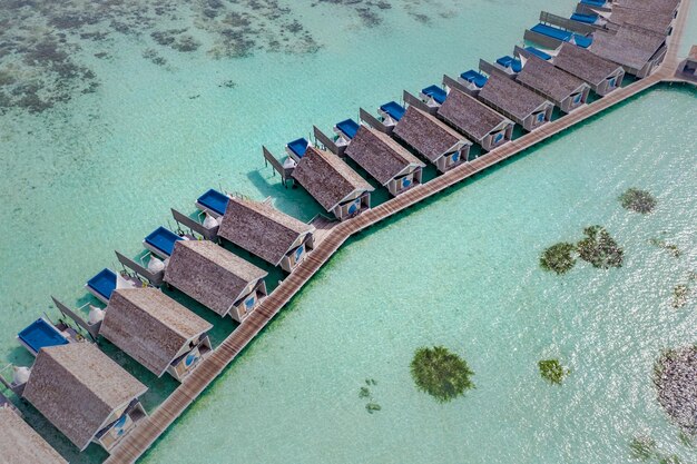 Widok z lotu ptaka na luksusowe wille na wodzie z basenami bez krawędzi na Malediwach. Egzotyczny krajobraz, widok z góry na zatokę morską
