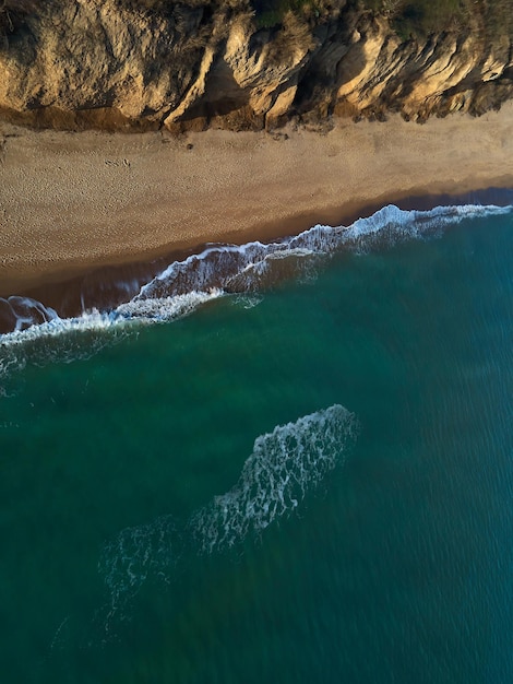 Widok z lotu ptaka na piaszczystą plażę i morze z falami, widok z góry, niesamowite tło przyrody, plaża i czysta woda, latający dron, widok na morze, miejsce.