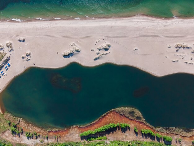 Widok z lotu ptaka na piaszczystą plażę, morze i jezioro nad Morzem Bałtyckim w Jantarnym, Obwód Kaliningradzki, Rosja