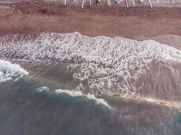 Widok Z Lotu Ptaka Na Plażę Amed Na Bali, Indonezja Tradycyjne łodzie Rybackie Zwane Jukung Na Czarnej, Piaszczystej Plaży I Wulkan Mount Agung W Tle Częściowo Zasłonięty Chmurami