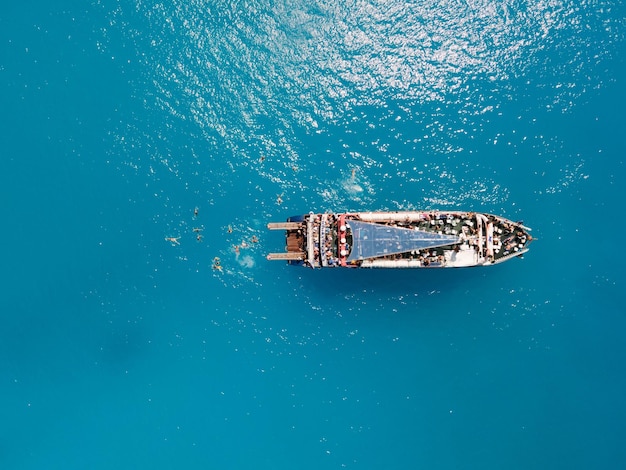 Widok z lotu ptaka na plażę porto katsiki z łodzią wycieczkową ludzie bawią się pływanie, skacząc, letnie wakacje w Grecji