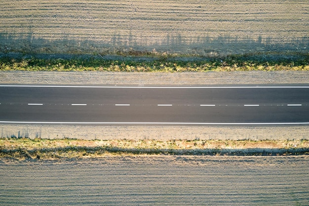 Widok z lotu ptaka na pustą drogę międzymiastową o zachodzie słońca. Widok z góry z drona autostrady wieczorem?