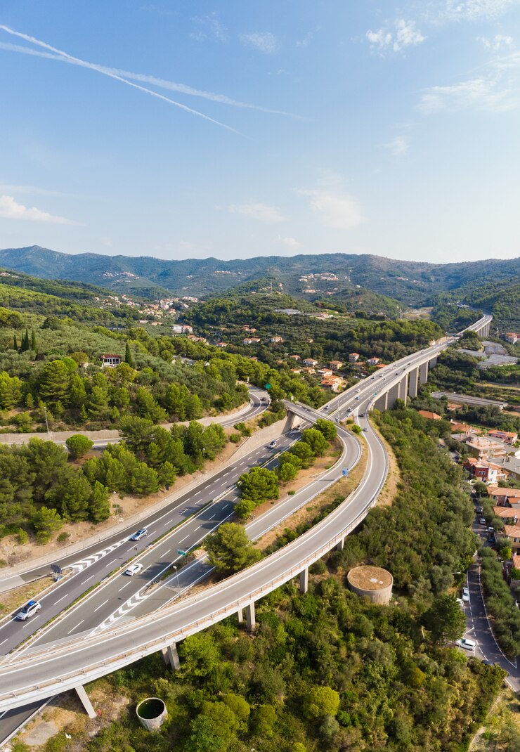 Zdjęcie widok z lotu ptaka na skrzyżowaniu wielu pasów ruchu wsie i wzgórza leśne (autostrada dei fiori - a10) liguria włochy