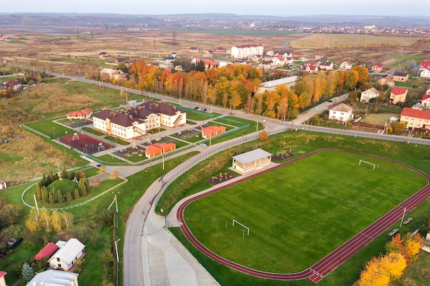 Widok Z Lotu Ptaka Na Stadion Sportowy Z Czerwonymi Bieżniami I Boiskiem Piłkarskim Na Zielonej Trawie.