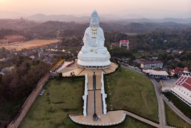 Widok z lotu ptaka na świątynię Wat Huay Pla Kang z Guanyin i kościołem o zachodzie słońca w prowincji Chiang Rai