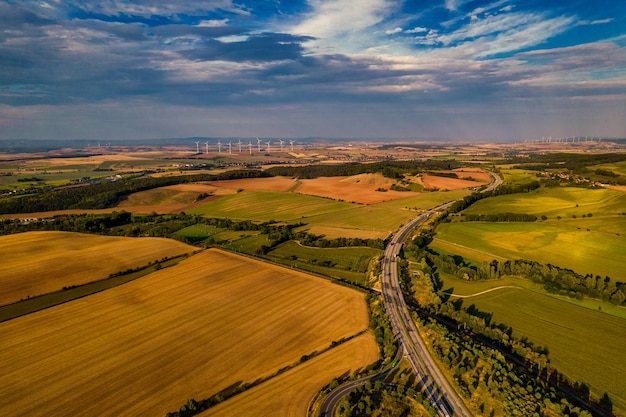 Zdjęcie widok z lotu ptaka na typowe zielone łąki w ardenach i krajobraz wzgórza, pokazujący również autostradę i budynki w odległym tle tego niemieckiego środowiska niemcy