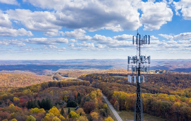 Widok z lotu ptaka na wieżę telefonii komórkowej nad zalesionym obszarem wiejskim Wirginii Zachodniej w celu zilustrowania braku szerokopasmowego dostępu do Internetu