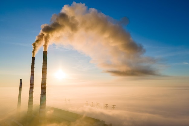 Widok Z Lotu Ptaka Na Wysokie Rury Elektrowni Węglowej Z Czarnym Dymem Poruszającym Się W Górę Zanieczyszczającej Atmosfery O Wschodzie Słońca.